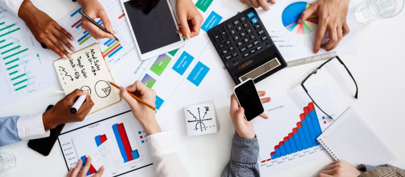empresarios-manos-sobre-mesa-blanca-con-documentos-y-borradores